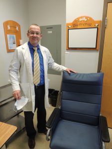  Le chef de service du CSSS du Granit, Rémy Lalancette, pose avec un fauteuil spécialisé, acquis grâce à la contribution de la Fondation, pour les usagers de l'USLD du quatrième étage de l'établissement. (Crédit-photo : Ronald Martel) - Fondation du CSSS du Granit